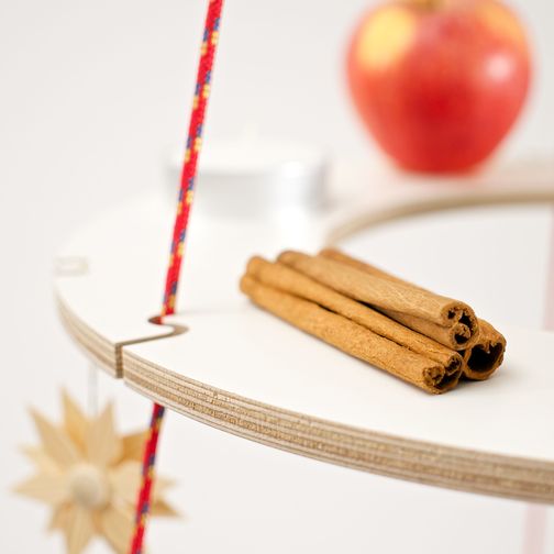 Cinnamon sticks are used as tree ornaments on a plywood ring of the alternative Christmas tree