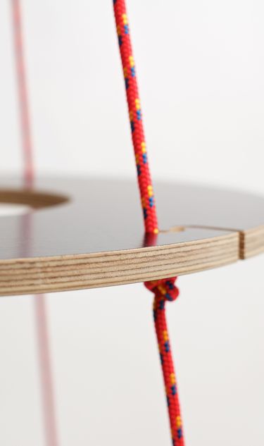 The ecological Christmas tree is made from plywood rings with a black surface and red ropes