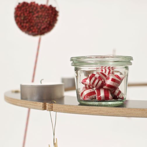 Bunte Bonbons in einem Glas als Weihnachtsschmuck auf dem festlich dekoriertem ökologischen Weihnachtsbaum Josef