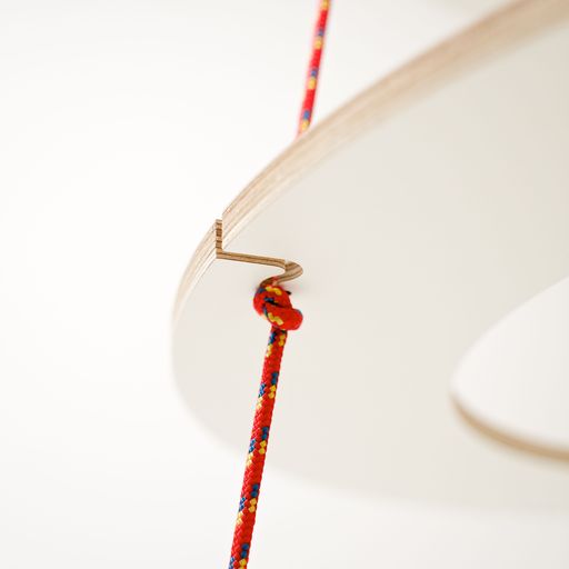 Detail of the rope feed on the alternative Christmas tree made of white laminated plywood rings and red ropes