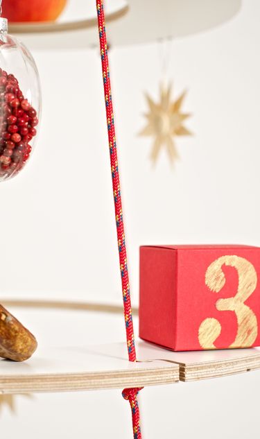 A box with a number on it is placed on a plywood ring advent Calendar